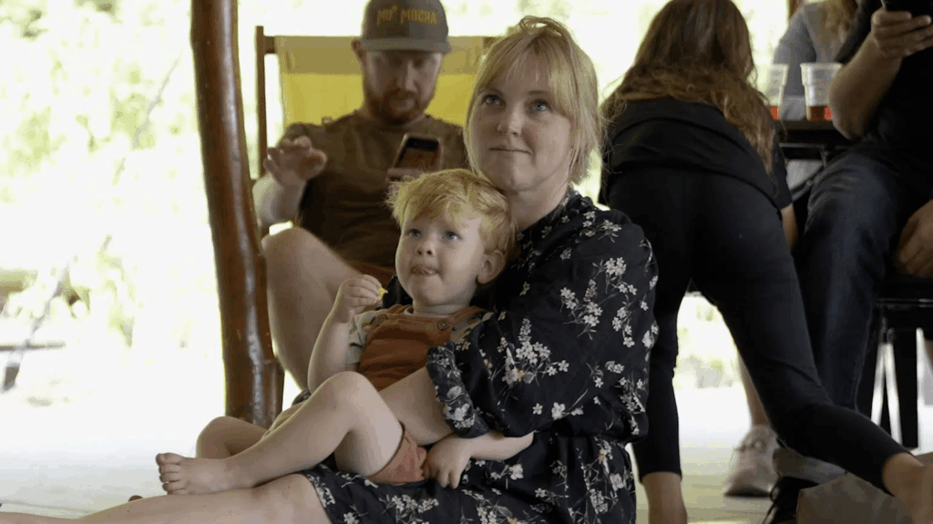 Moeder met kindje op schoot kijkend naar een voorstelling